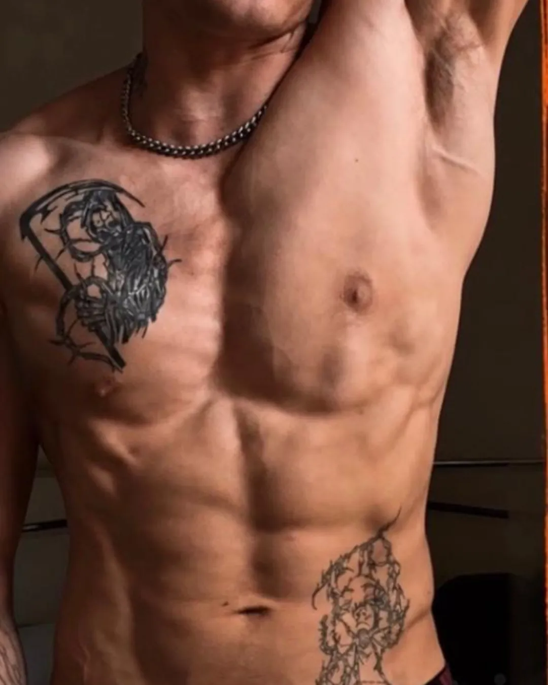 The coach in the gym, back turned, holding a double biceps pose
